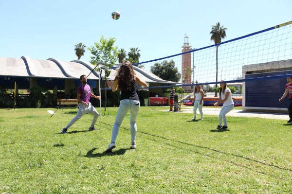 En la imagen, estudiantes juegan al voleibol. 