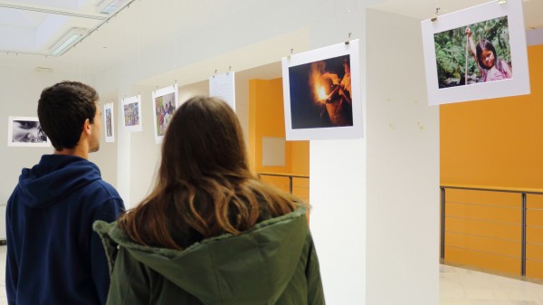Dos estudiantes contemplan las fotos de la exposición en la Biblioteca UPO