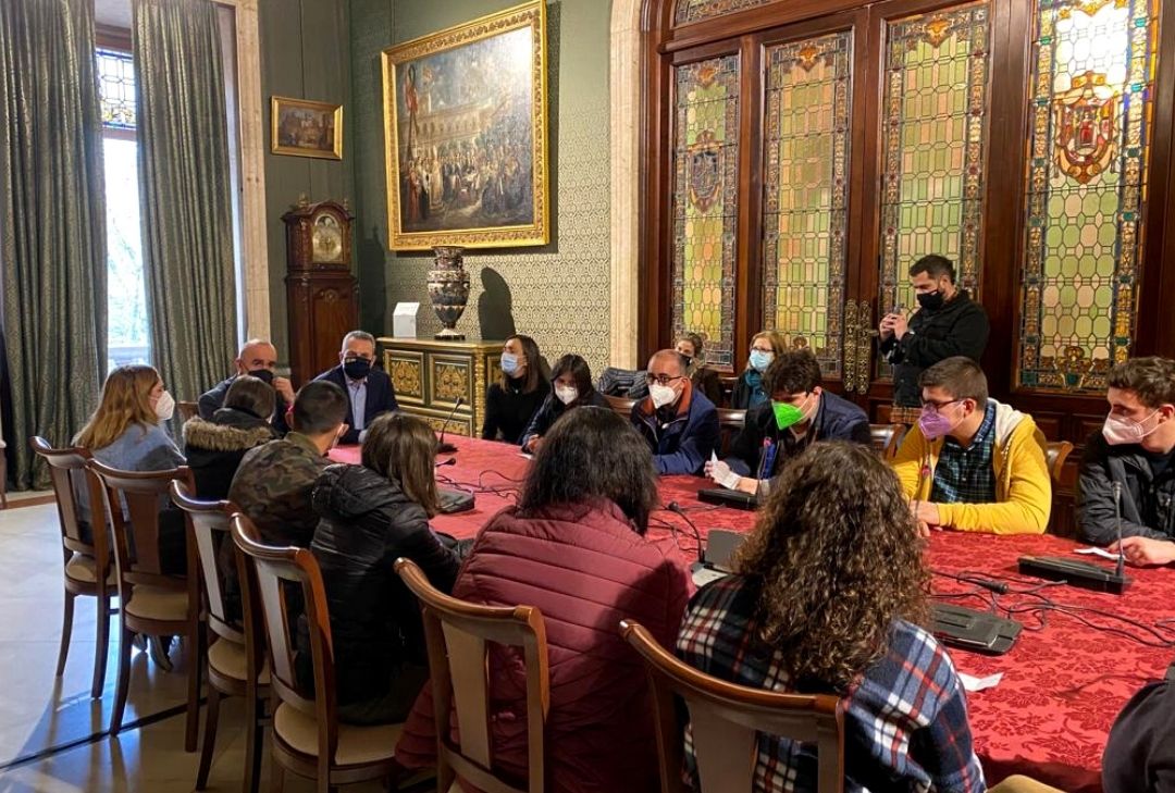 Estudiantes de FEVIDA sentados en torno a una mesa junto al alcalde de Sevilla